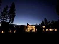 a house lit up at night with trees in the background