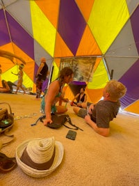 a group of people sitting in a colorful tent