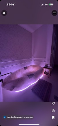 a photo of a room with purple lights and a bed